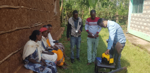 Women and men outside looking at a solar power lamp.