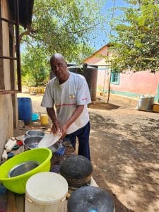 A man washing a white dish. 